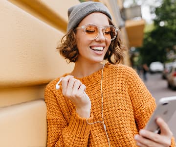 girl in a yellow sweater listening to an online course